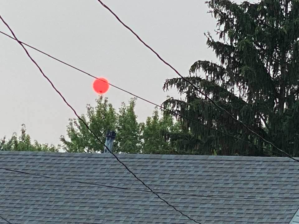 Red sun in the evening over a house