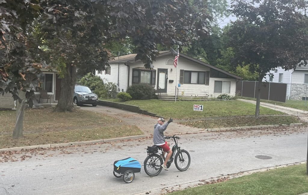 Opa runs on bicycle with trailer to go and collect trash